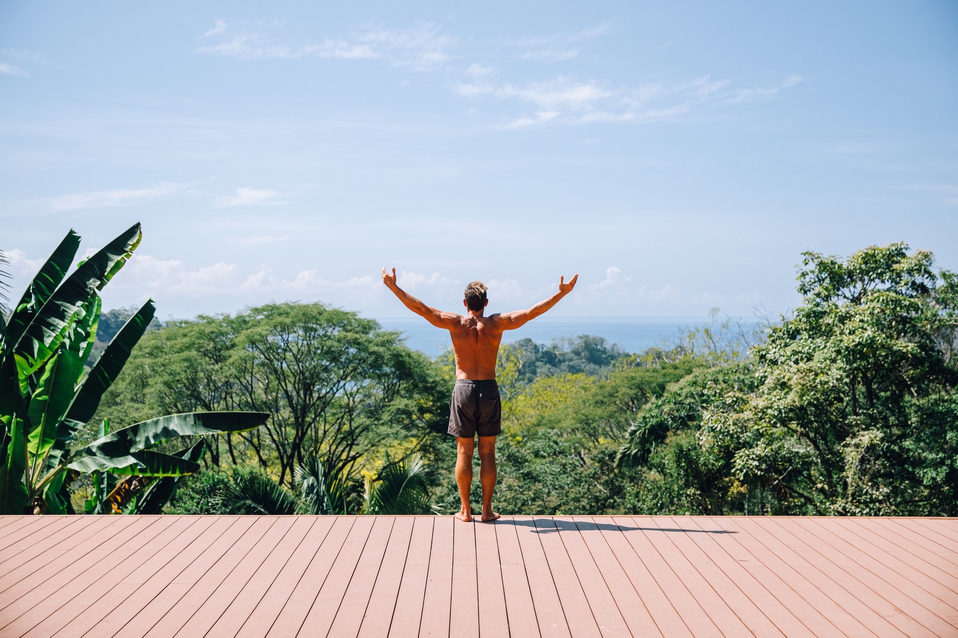 Paul Saladino on a jungle deck, arms raised to the view