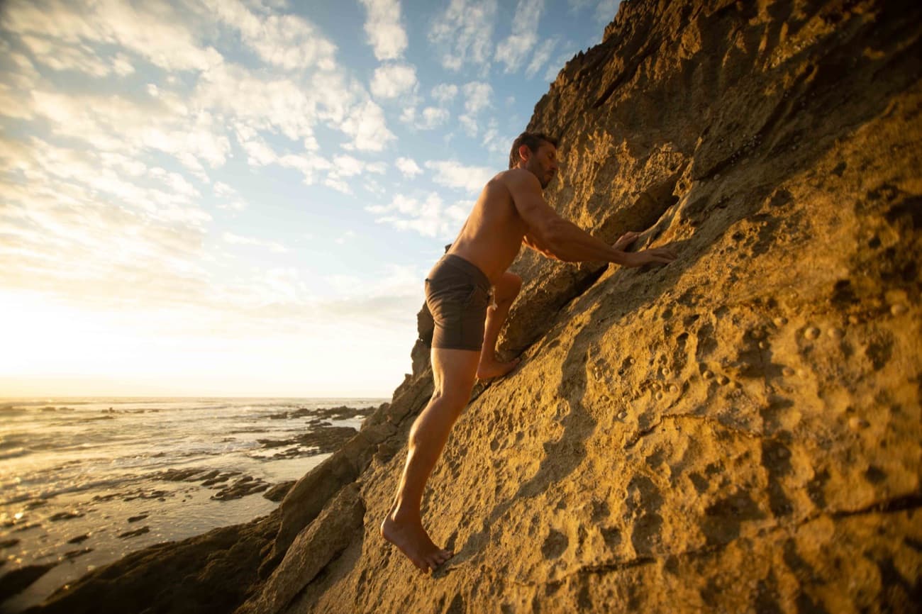 Paul climbing rock at sunset